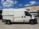 a white van parked in a parking lot with other trucks in the background