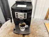 a coffee maker sitting on a table with a cup of coffee