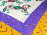 purple, yellow, and green table cloth with a picture of horses on it
