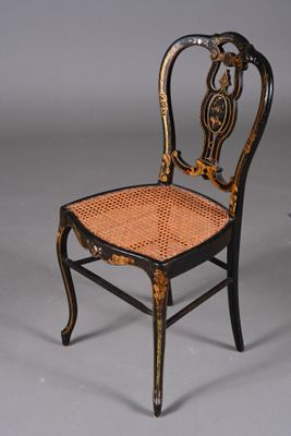 paire de chaises peintes en noir et or, avec des assises en osier