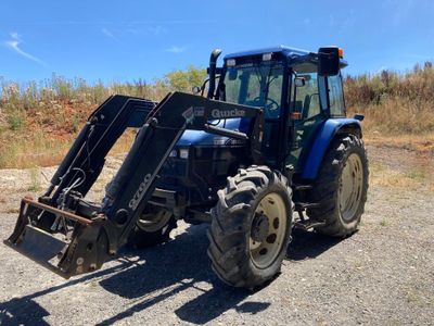 un tracteur bleu garé sur le bord de la route
