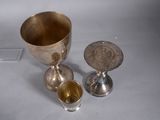two silver cups and a silver cup on a white surface