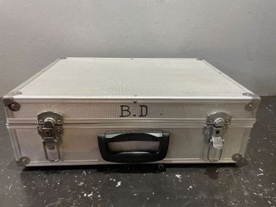 une valise blanche munie d'une poignée noire, posée sur une table