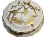 a white and gold plate with a bird on it