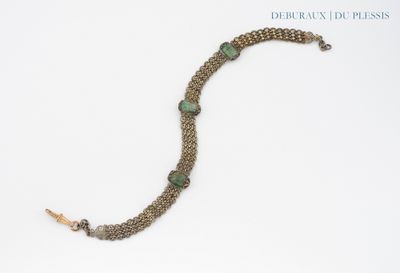 bracelet composé de perles de verre vertes et d'une chaîne en argent sur fond blanc