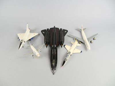 Plusieurs maquettes d'avions sont alignées sur une surface blanche