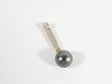 a close up of a black pearl and diamond pendant on a white surface