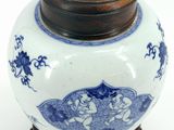 a blue and white vase with a lid on a wooden stand