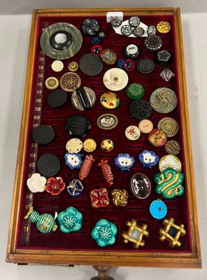 une vitrine en bois contenant de nombreux boutons