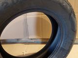 tire on the floor next to a wall with a hole in it
