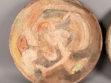 pair of ceramic bowls with designs on them on a gray surface