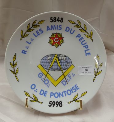 une assiette ornée d'un emblème maçonnique, posée sur une table