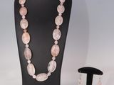 un gros plan sur un ensemble composé d'un collier et de boucles d'oreilles, présenté sur un mannequin