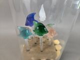 a glass vase filled with different colored glass birds