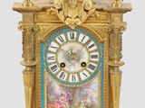 une horloge dorée et bleue surmontée d'un oiseau