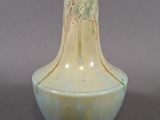 un vase blanc et bleu posé sur une surface grise
