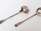 two spoons that are sitting next to each other on a table