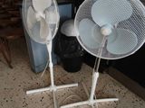 two white fans that are on the floor in front of a tv