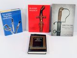 trois livres sont posés les uns à côté des autres sur une surface blanche