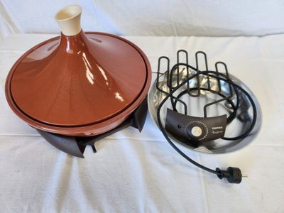 a brown vase and a black wire on a white sheet