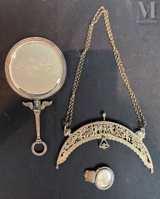 a gold necklace and a mirror on a black table