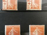 four stamps of different sizes and colors on a black surface