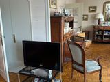 hardwood flooring in a living room with a flat screen tv on a stand