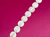 an image of a bracelet made out of coins on a pink surface