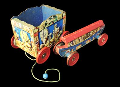 a toy wagon with a ball in it on a black background