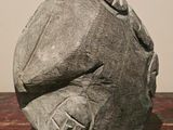 a stone sculpture of a face on a wooden table