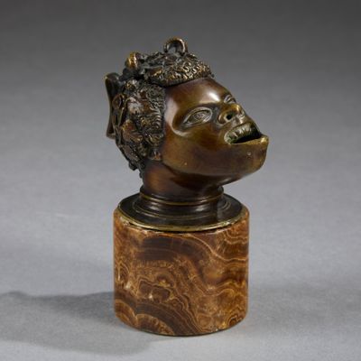 a bronze bust of a woman with a crown on top of a wooden base