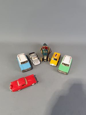 several toy cars are lined up in a row on a gray surface