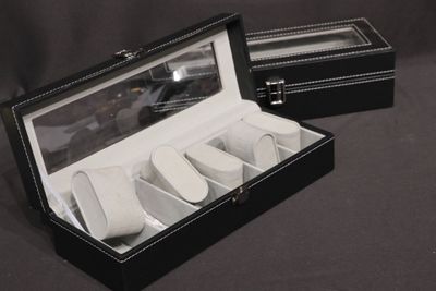 a black box that has a set of four watches inside of it