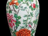 un vase blanc orné de fleurs rouges sur fond noir