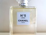 un flacon de parfum Chanel n° 5 posé sur une table, sur fond blanc
