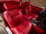 the interior of a red car with leather seats and a steering wheel