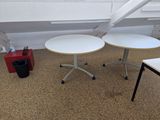 two tables and a chair in the corner of a room