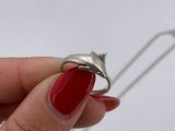 someone is holding a silver ring with a red stone in it