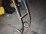 un diable sur lequel est posé un vélo, dans un garage