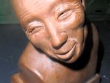 une sculpture en argile représentant le visage d'un homme, posée sur une table