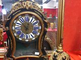 une horloge posée sur une table devant un miroir