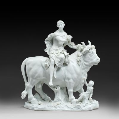 an image of a statue of a woman riding on a cow