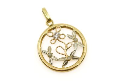 un pendentif en or orné d'un motif représentant une fleur et des feuilles