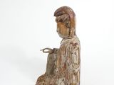 wooden statue of a woman sitting on a white surface
