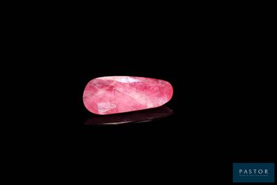 un quartz rose posé sur une surface noire