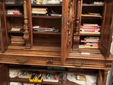a wooden cabinet that has a lot of books on it
