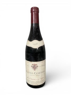 une vieille bouteille de vin posée sur une surface blanche