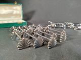 a silver necklace that has a bunch of silver beads on it