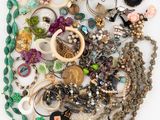an image of a pile of assorted jewelry on a white surface