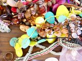 un tas de bijoux en tout genre posé sur une table en bois